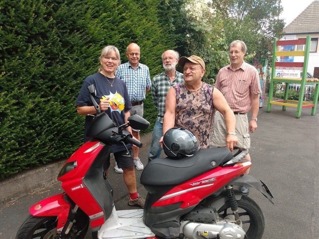 Bärbel, Raffaele mit Roller und einige Reparateure des Reparaturtreffs bei der Übergabe des Fahrzeugs