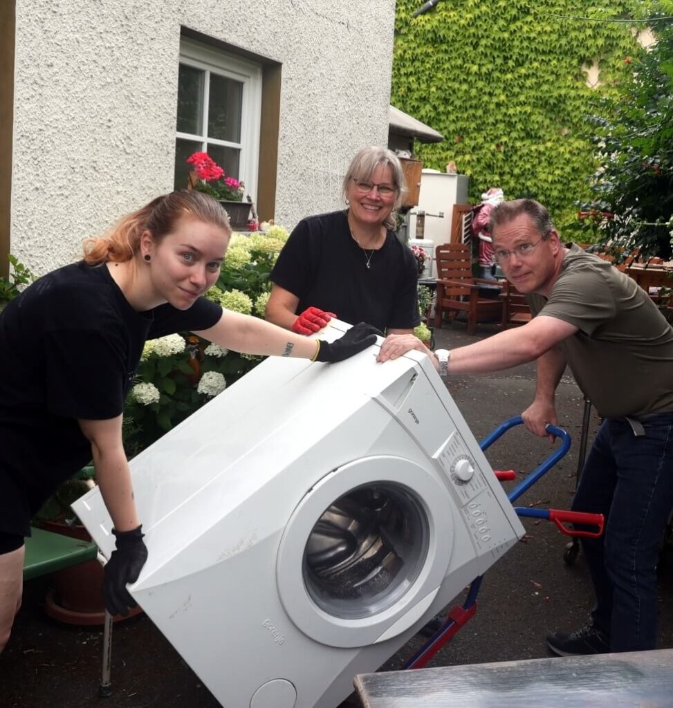 Verena, Bärbel und Wolfgang mit einer reparierten Waschmaschine