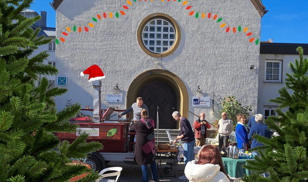 Blick auf den Hof der Werkstattkirche mit der Gulaschkanone der Lugredu Stiftung bei Supp und Schwätze. Im Vordergrund als Fotomontage Tannenbäume