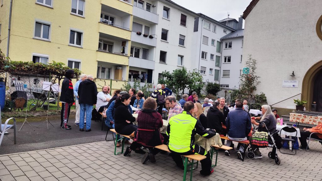 Blick auf die vollbesetzten Tische im Hof der Werkstattkirche